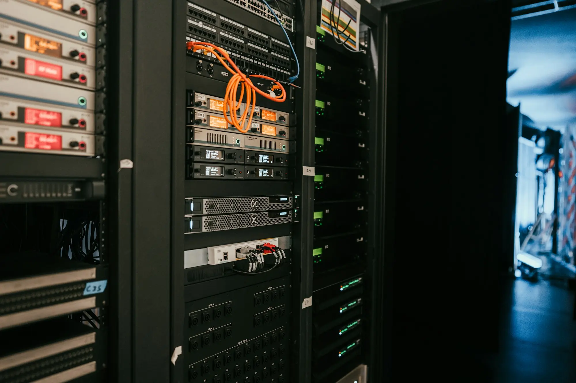 A rack of servers with status lights in a dim server room.